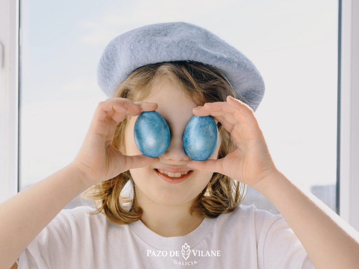 Nena con dous ovos azuis cubríndolle os ollos.