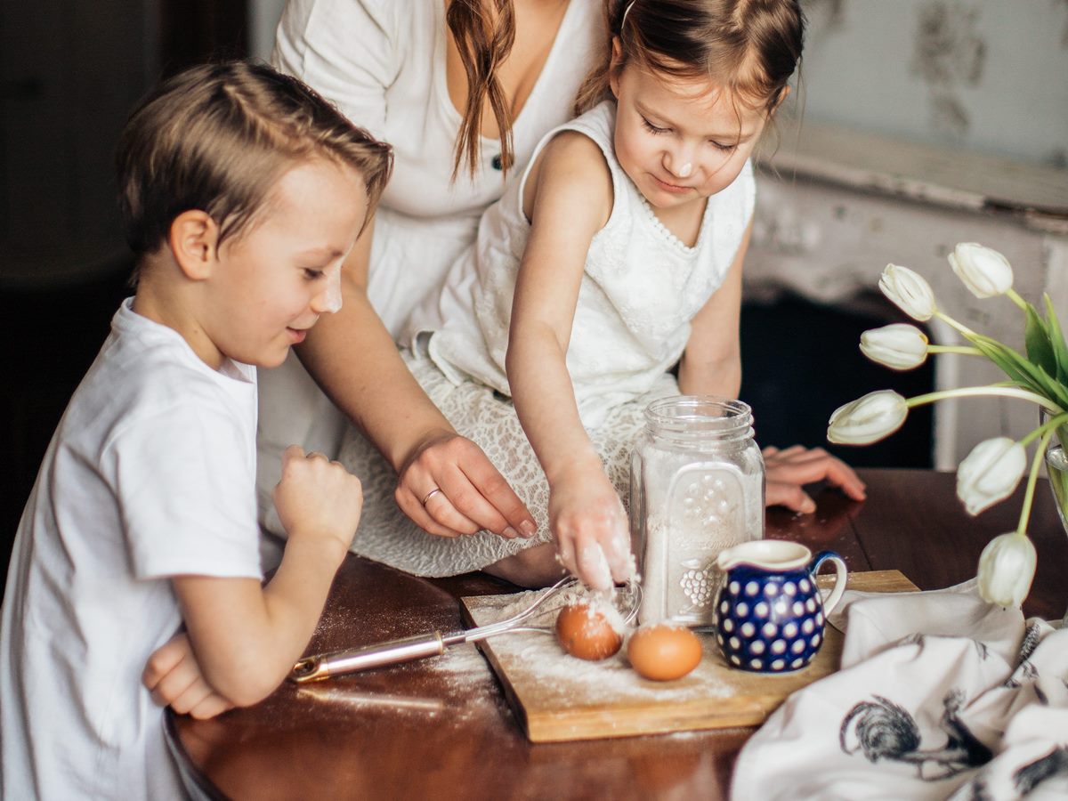 Niños cocinando huevos con su madre